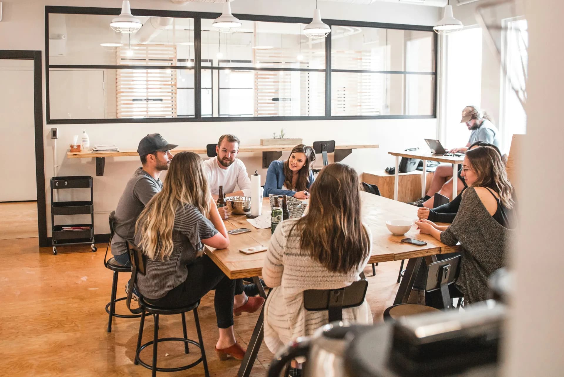 Groupe de personnes échangeant autour d’une table, illustrant l’importance de recueillir des opinions par un sondage