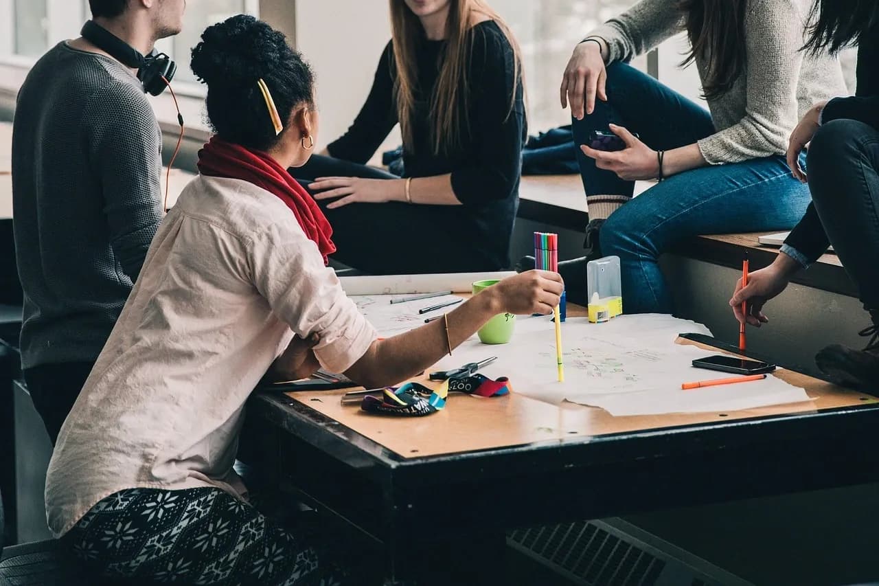 Groupe de jeunes discutant autour d’une table lors d’un sondage d’opinion.